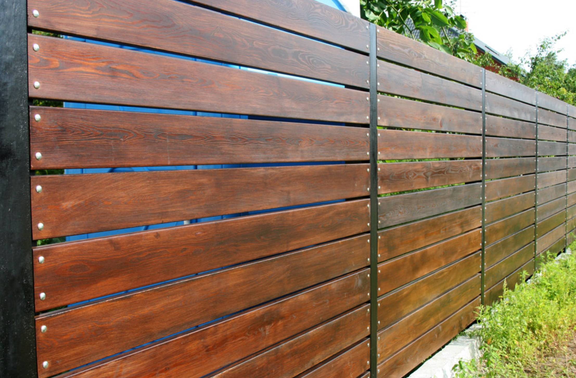 Деревянный забор на металлических столбах: особенности строительства